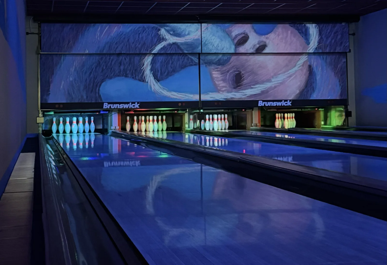 Bowlingbahn mit leuchtenden Pins im Schwarzlicht
